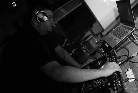 CHIEF mixing at his controller in a black-and-white performance photo